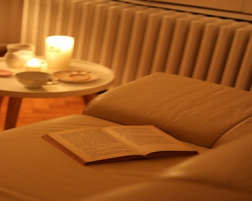 Relaxing evening reading a book on a comfortable sofa with warm lighting